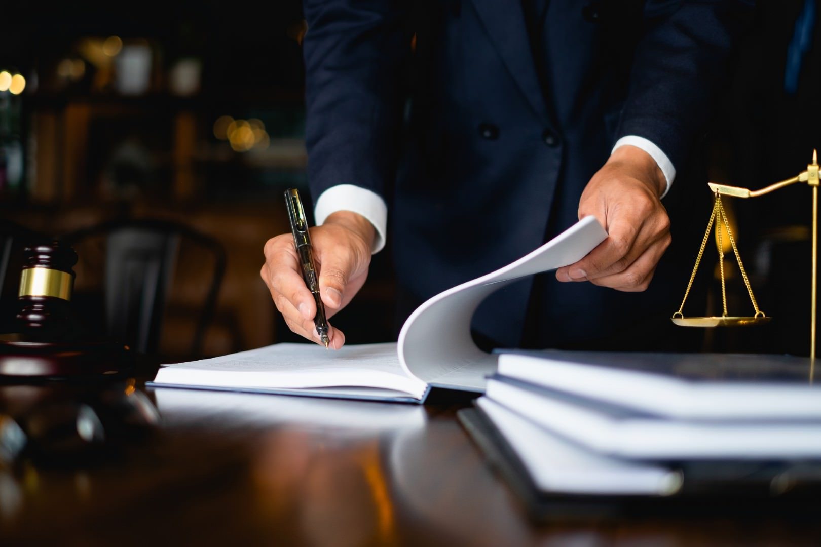 San Diego business attorney reviewing legal documents beside a gavel and scales of justice